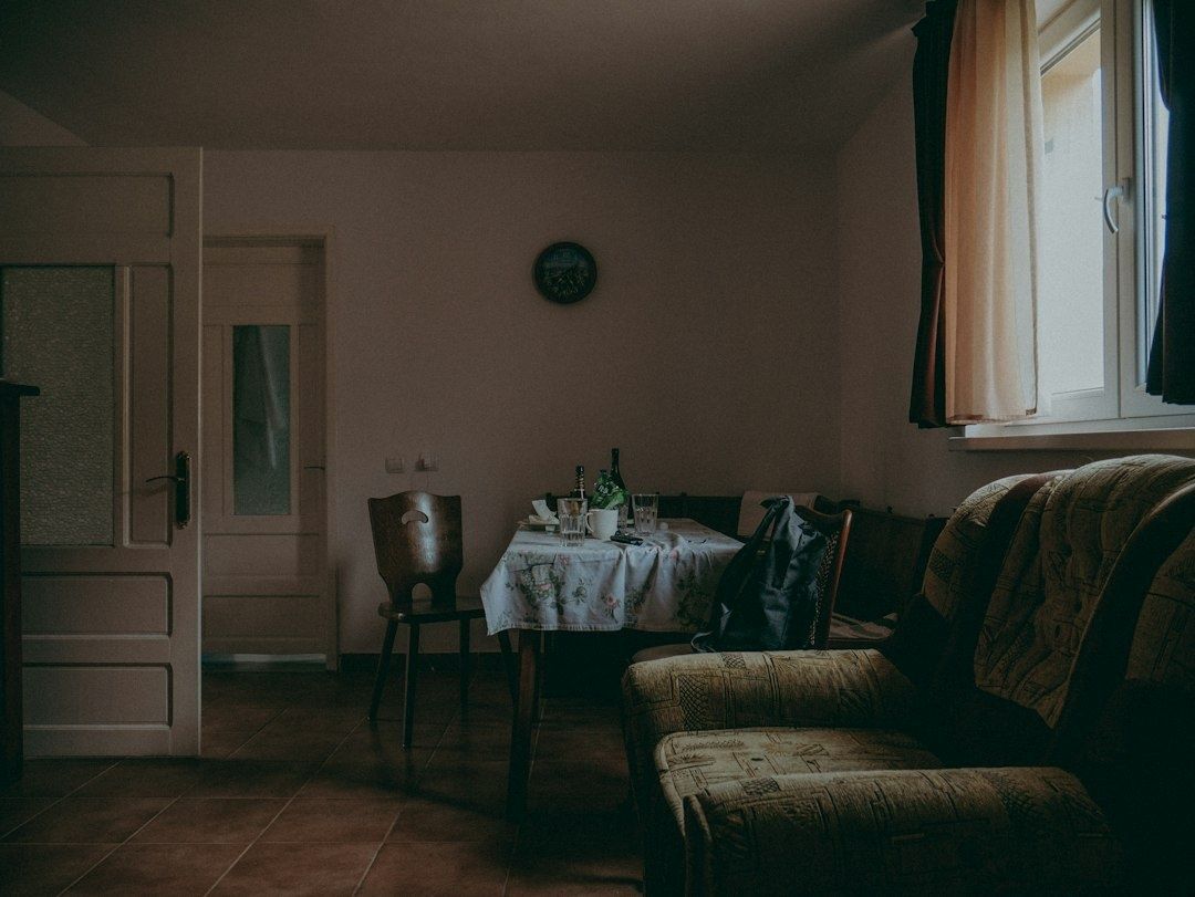 Dunkles Wohnzimmer mit gedecktem Tisch, Sofa und hohen Wänden